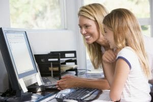 mom and daughter at computer sharing information, smiling