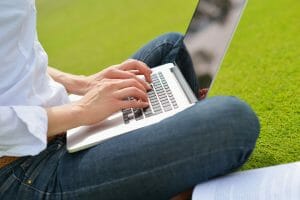 woman with laptop in park/business productivity/sanespaces.com