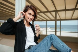 Adult ADHD woman in earphones sitting and listening, audio adaptability, productivity strategies