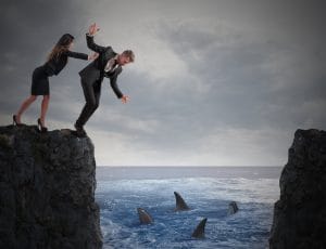 woman pushing man off cliff into circling sharks